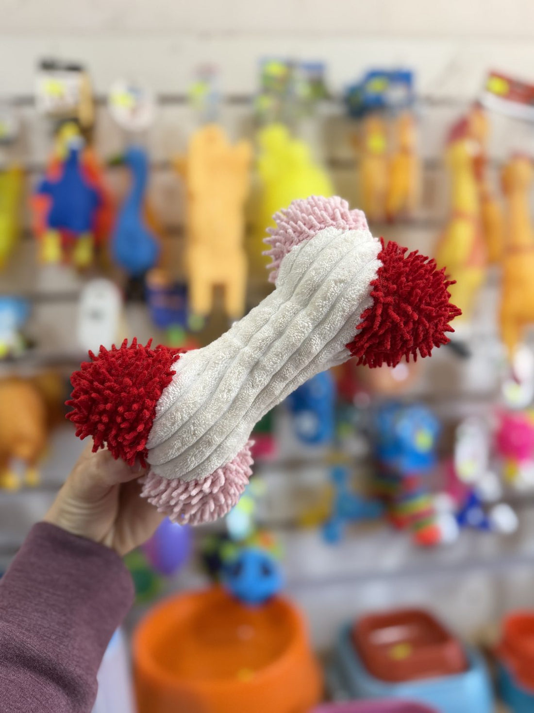 Hueso de peluche con pompones rojo y blanco